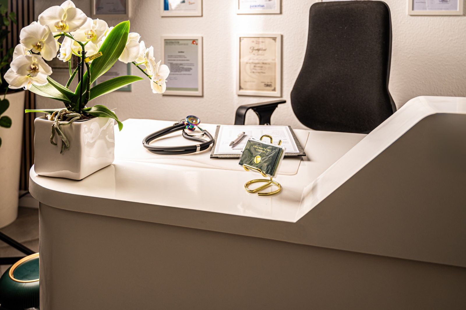 Empfangstresen mit wei&szlig;er Orchidee und Stethoskop