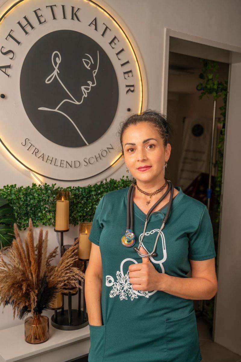 Lidia Brosius vor der Logo-Wand ihres Ateliers